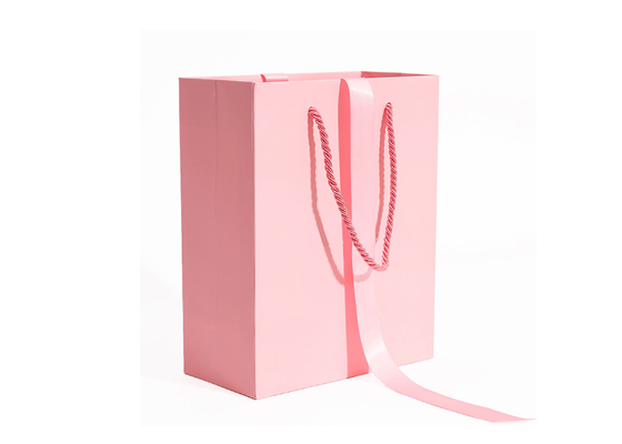 ロープのハンドルが付いている注文のロゴのロマンチックなピンクの下着の買物をする紙袋